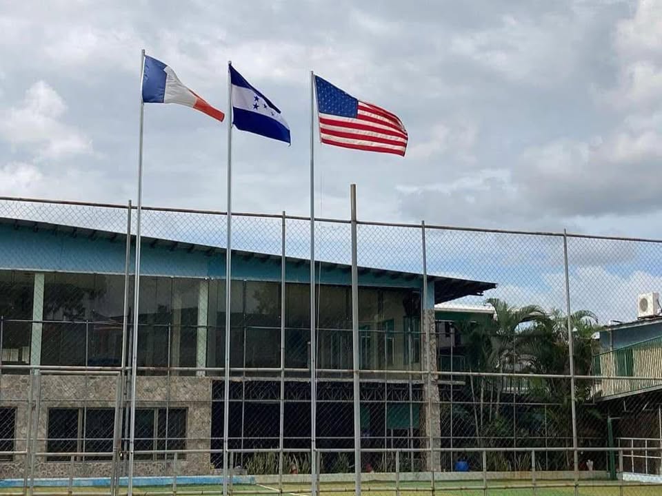 Albert Einstein International School campus and courtyard, with the flags of France, Honduras, and the United States